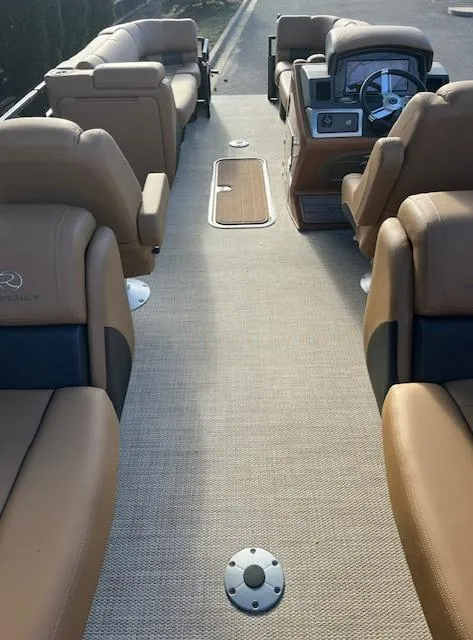 Slide: The Image of 2024 Regency 230 LE3 pontoon boat interior with tan leather seating and modern dashboard. - 22