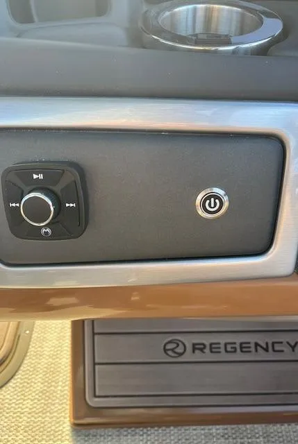 Slide: The Image of Control panel of 2024 Regency 230 LE3 boat with power button and audio controls. - 24