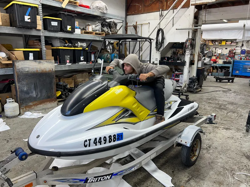 Slide: The Image of 2005 Yamaha WaveRunner GP 800R in a workshop, person sitting on it. - 1