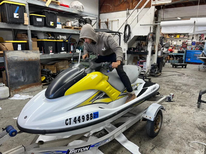 Slide: The Image of Man working on a 2005 Yamaha WaveRunner GP 800R in a cluttered workshop. - 2