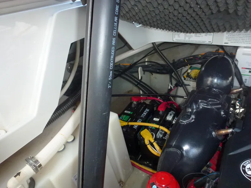 Slide: The Image of 2019 Crownline 264 CR engine compartment with battery and wiring. - 21