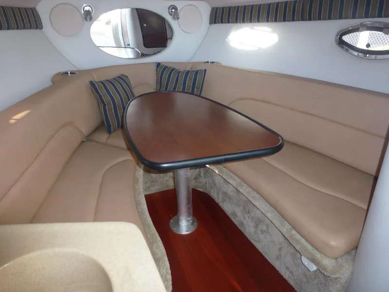 Slide: The Image of 2019 Crownline 264 CR cabin interior with beige seating and wooden table. - 22