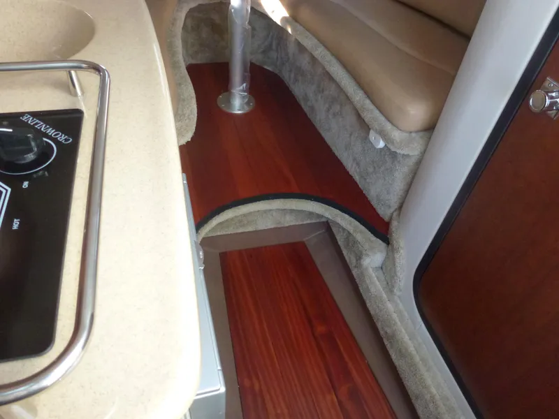 Slide: The Image of 2019 Crownline 264 CR cabin interior with wood flooring and beige seating. - 23