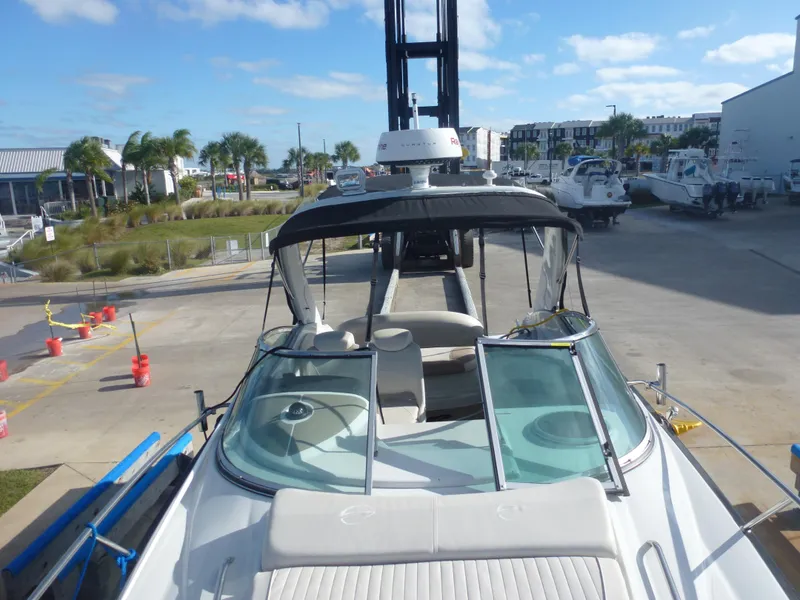 Slide: The Image of 2019 Crownline 264 CR boat docked at a marina with palm trees in the background. - 9