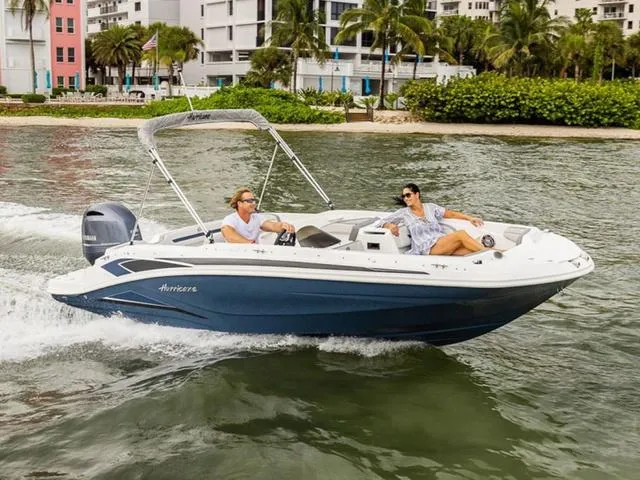 Slide: The Image of 2024 Hurricane SunDeck Sport 205 OB cruising on water near a tropical shoreline. - 1