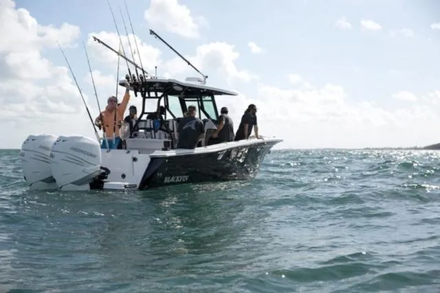 Slide: The Image of 2024 Blackfin 272CC boat with passengers on open water, fishing rods visible. - 6