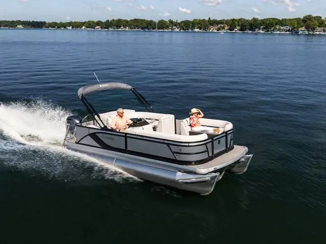 Slide: The Image of 2024 Sweetwater SW 2486 C pontoon boat cruising on a lake. - 1