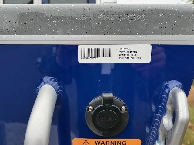Slide: The Image of 2023 Spartan 220 Maximus Pro, admiral blue, with warning label and barcode. - 12