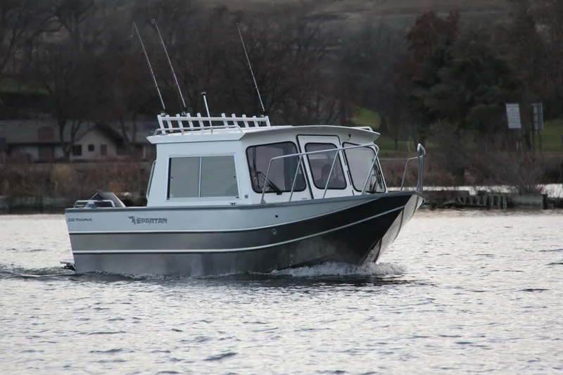 Slide: The Image of 2023 Spartan 220 Maximus Pro boat cruising on a lake. - 14