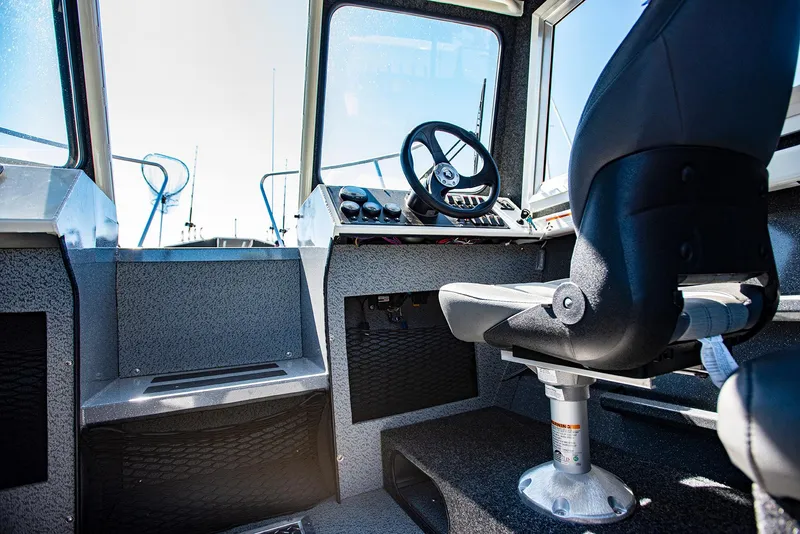 Slide: The Image of Interior cockpit of 2023 Spartan 220 Maximus Pro boat with steering wheel and captain's chair. - 24