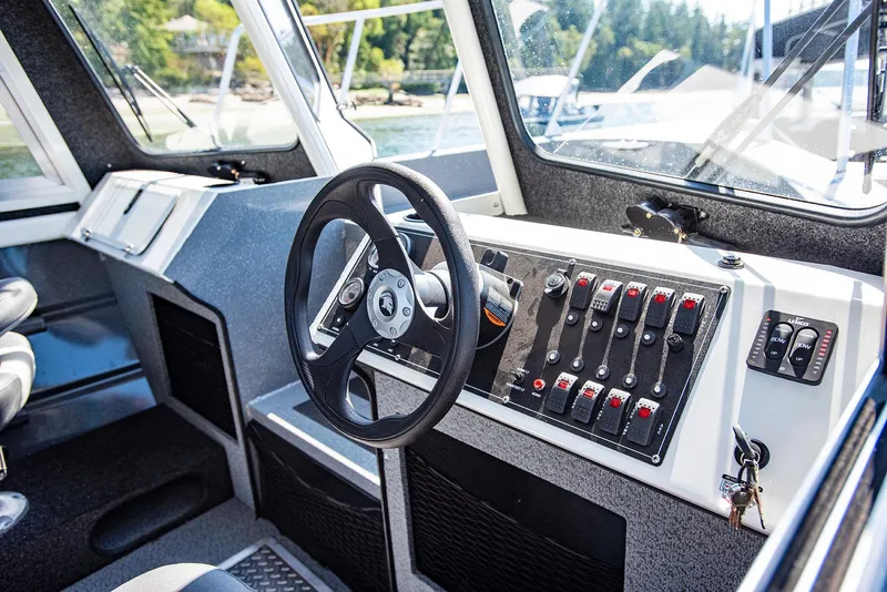 Slide: The Image of 2023 Spartan 220 Maximus Pro boat cockpit with steering wheel and control panel. - 25