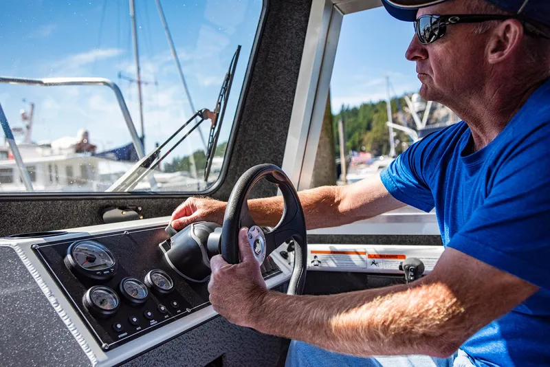 Slide: The Image of Man steering 2023 Spartan 220 Maximus Pro boat on a sunny day. - 26