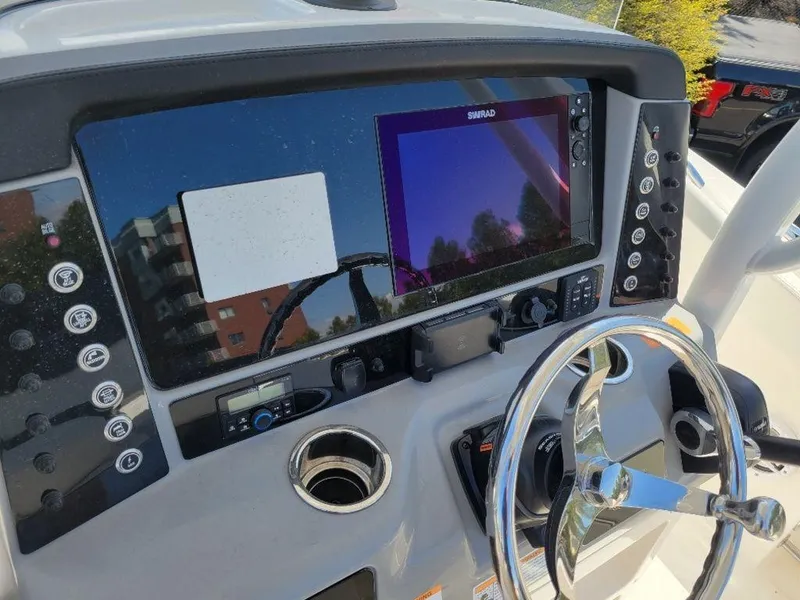 Slide: The Image of 2024 Robalo R232EX boat dashboard with steering wheel and electronic controls. - 13