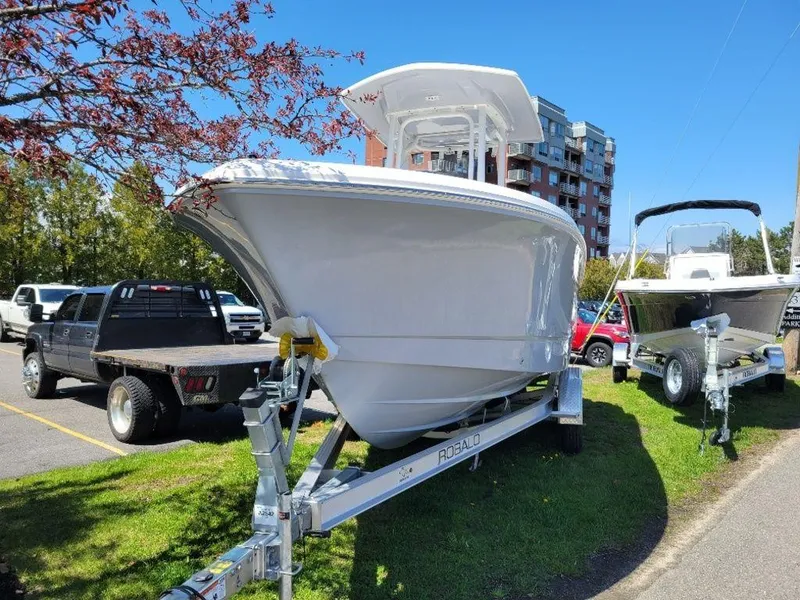 Slide: The Image of 2024 Robalo R232EX boat on trailer in outdoor display. - 2