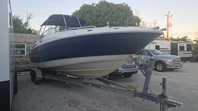 Slide: The Image of 2002 Monterey 262 Cruiser boat on a trailer in a parking lot. - 1