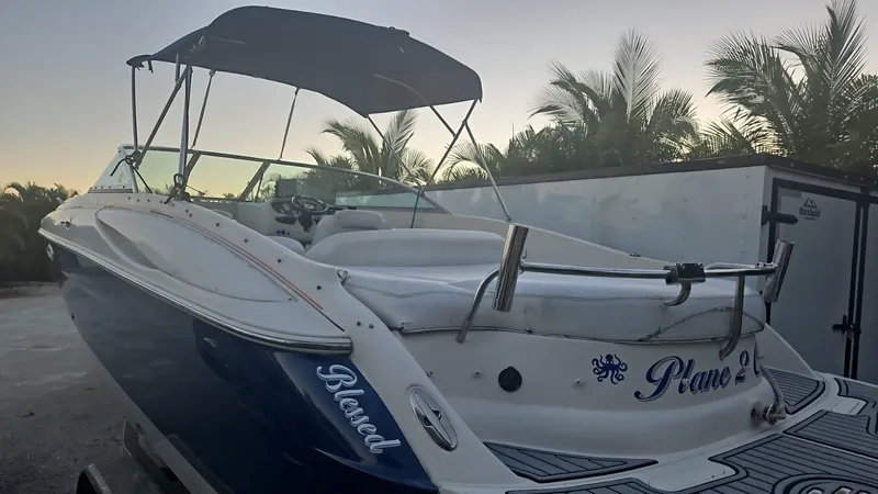 Slide: The Image of 2002 Monterey 262 Cruiser boat with canopy, docked near palm trees. - 2