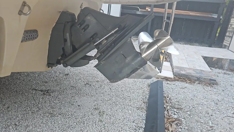 Slide: The Image of 2002 Monterey 262 Cruiser boat propeller and outdrive on gravel surface. - 3