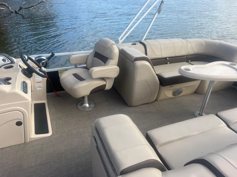 Slide: The Image of 2018 Sun Tracker Party Barge 22 DLX interior with beige seating and steering console. - 17