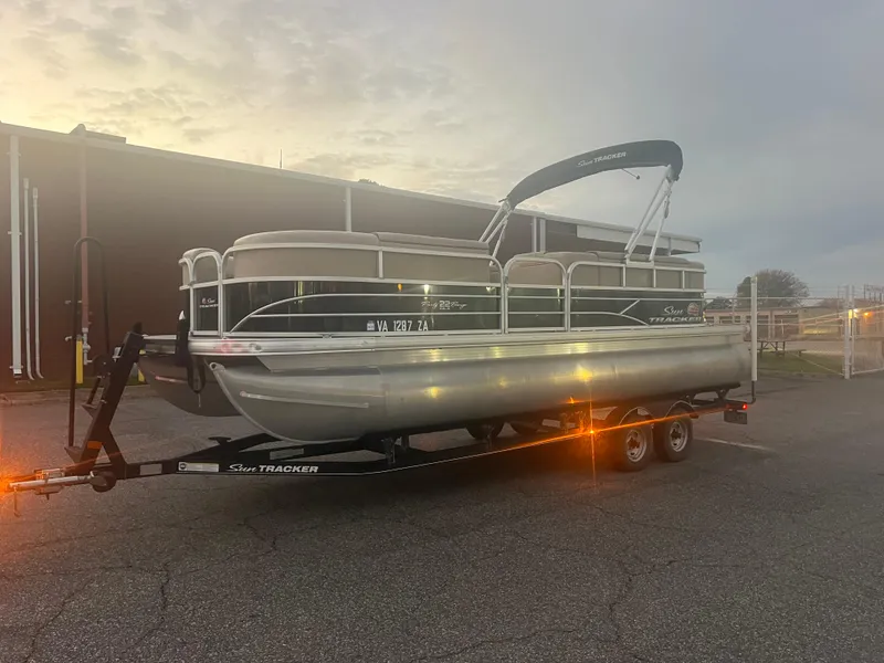 Slide: The Image of 2018 Sun Tracker Party Barge 22 DLX pontoon boat on trailer at sunset. - 4