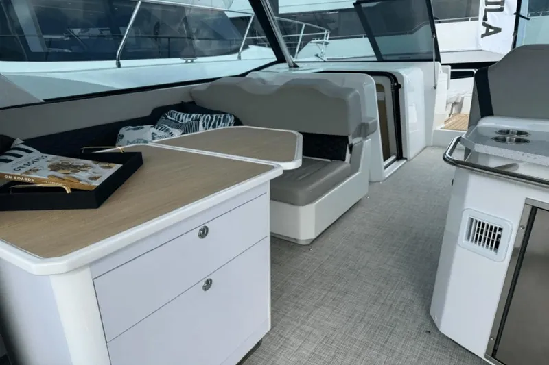 Slide: The Image of Interior of 2024 Aquila 36 Sport yacht with seating, table, and kitchenette. - 11