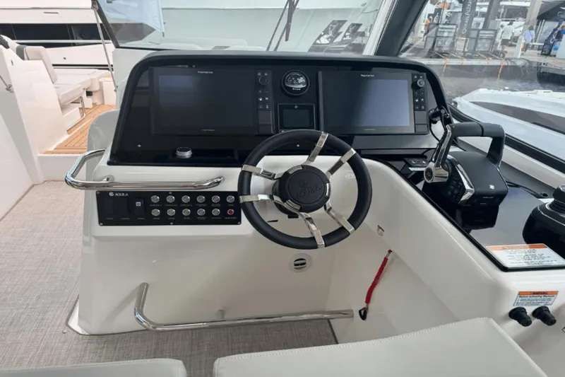 Slide: The Image of 2024 Aquila 36 Sport boat helm with dual Raymarine displays and modern controls. - 12