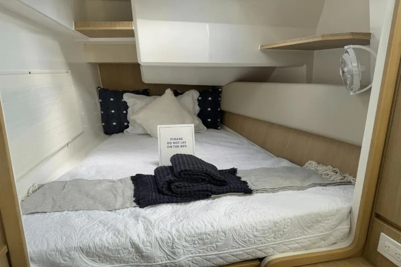 Slide: The Image of 2024 Aquila 36 Sport cabin with neatly made bed and pillows. - 14