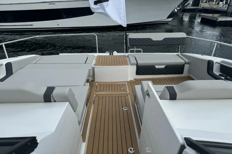 Slide: The Image of 2024 Aquila 36 Sport boat interior with teak flooring and cushioned seating. - 16