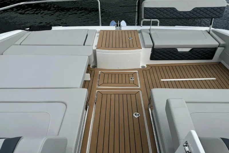 Slide: The Image of Interior deck of 2024 Aquila 36 Sport boat with cushioned seating and wooden flooring. - 17