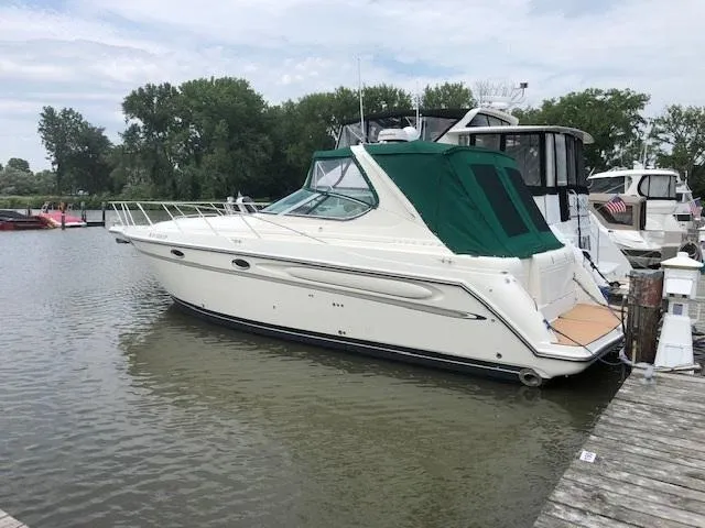 The Image of 1998 Maxum 3700 SCR yacht docked at a marina with green canopy. - 0