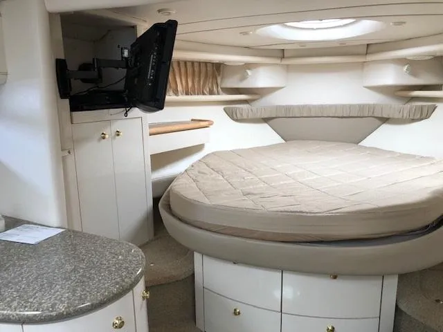 Slide: The Image of 1998 Maxum 3700 SCR boat interior with bed, TV, and storage cabinets. - 17