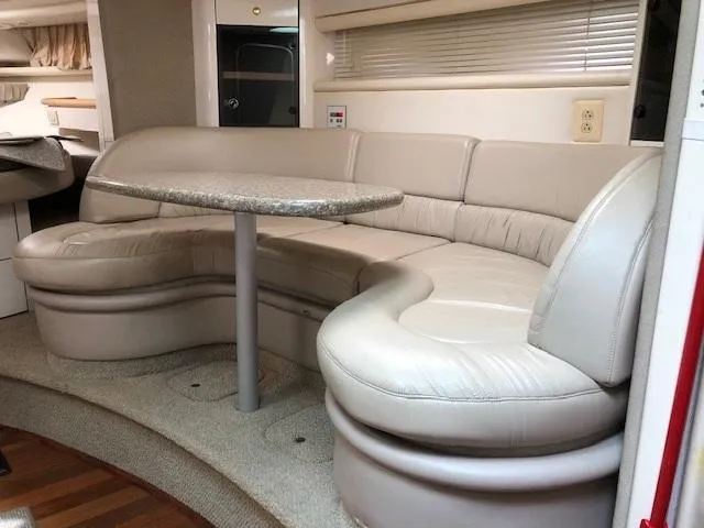 Slide: The Image of 1998 Maxum 3700 SCR yacht interior with curved leather seating and table. - 18