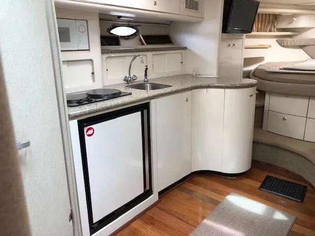 Slide: The Image of 1998 Maxum 3700 SCR yacht interior kitchen with modern appliances and wooden flooring. - 19