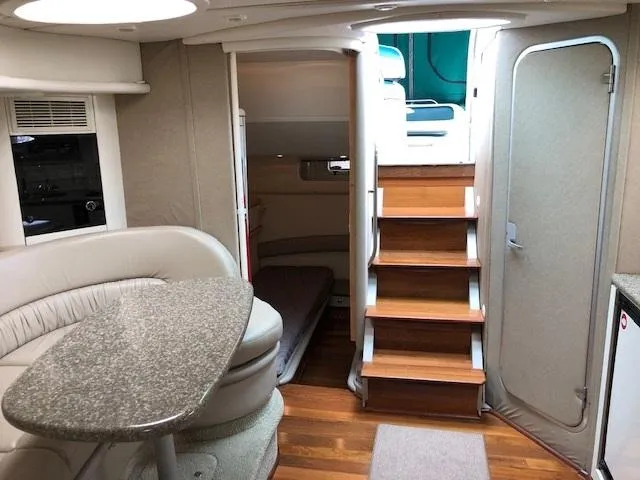 Slide: The Image of 1998 Maxum 3700 SCR yacht interior with stairs, seating, and table. - 21