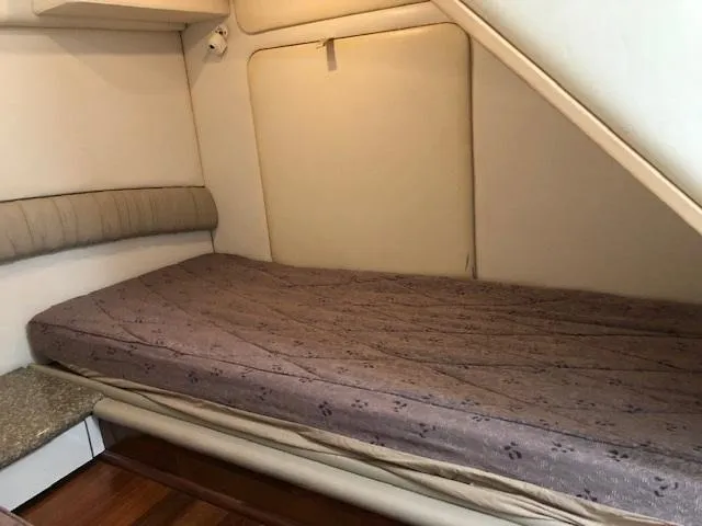 Slide: The Image of Interior cabin bed of 1998 Maxum 3700 SCR boat with beige walls and brown mattress. - 22