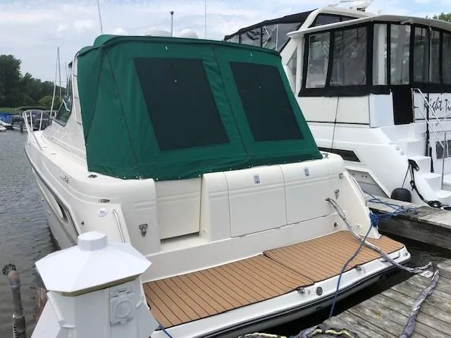 Slide: The Image of 1998 Maxum 3700 SCR yacht docked with green canvas cover. - 3