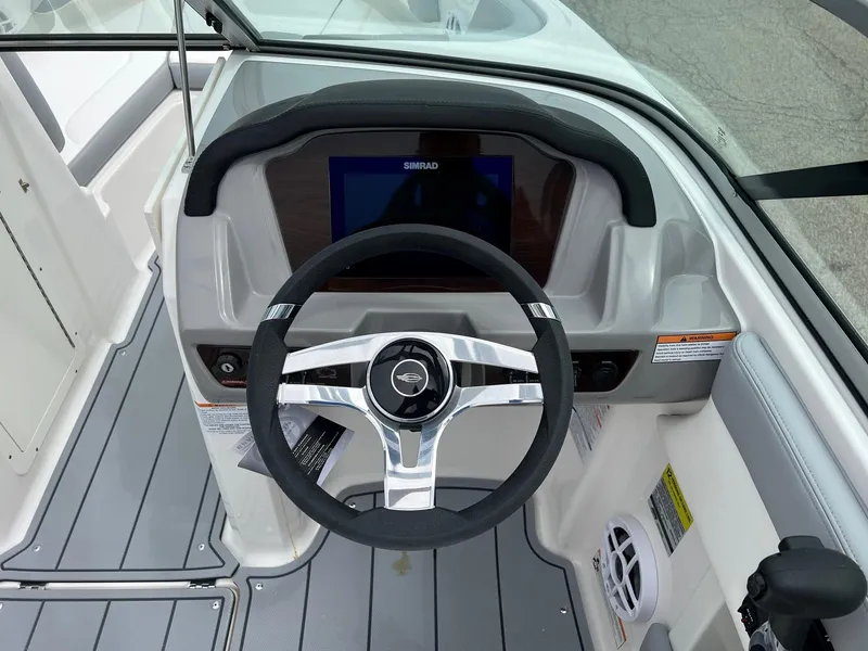 Slide: The Image of 2024 Chaparral 21 SSi boat dashboard with steering wheel and digital display. - 7