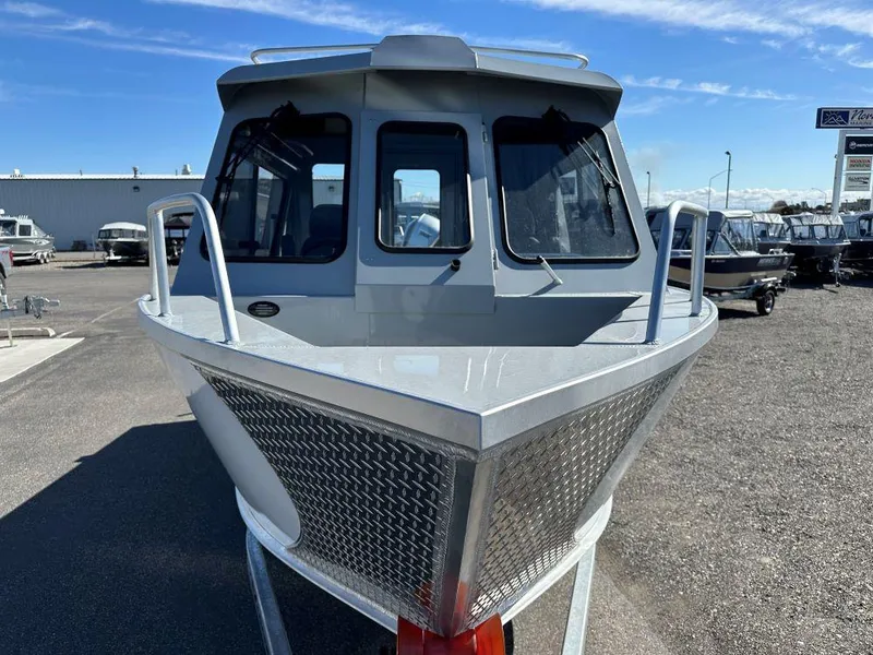 Slide: The Image of 2024 Hewescraft 220 Ocean Pro HT ET boat front view in a dealership lot. - 2