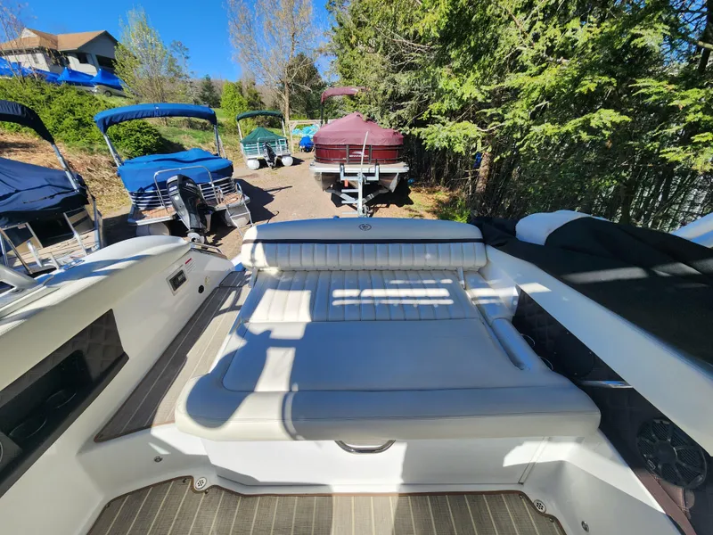 Slide: The Image of 2011 Cobalt A25 boat with white seating, docked among other boats. - 11