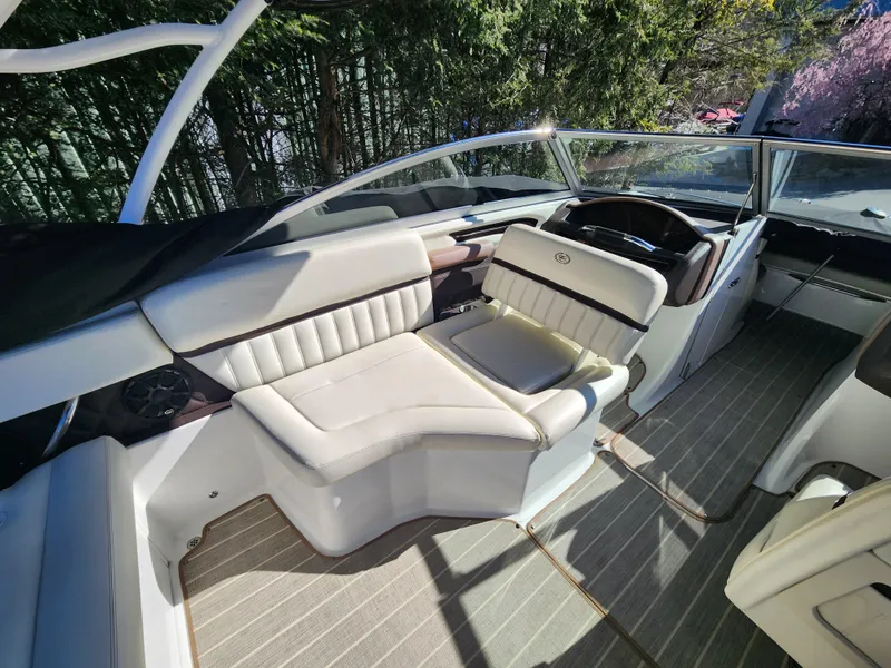 Slide: The Image of Interior of a 2011 Cobalt A25 boat with white leather seating and modern dashboard. - 23