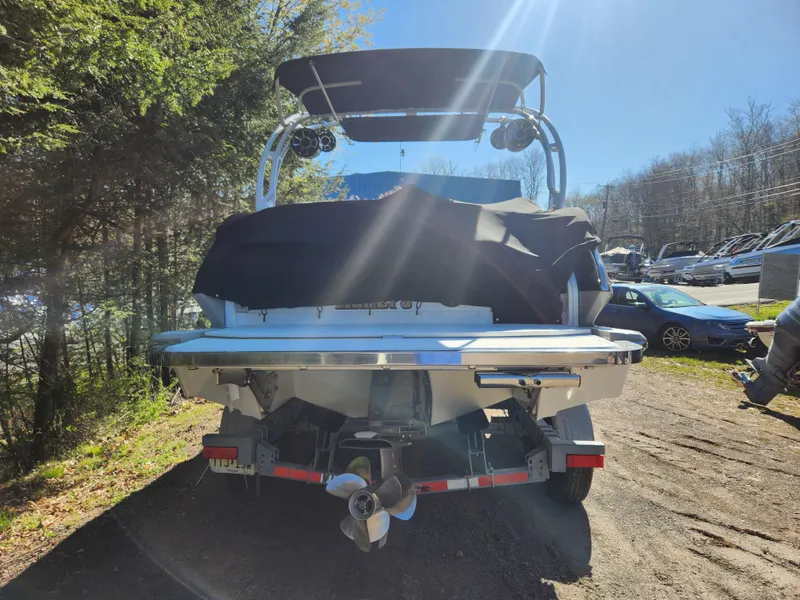 Slide: The Image of 2011 Cobalt A25 boat with cover, rear view, parked outdoors. - 3