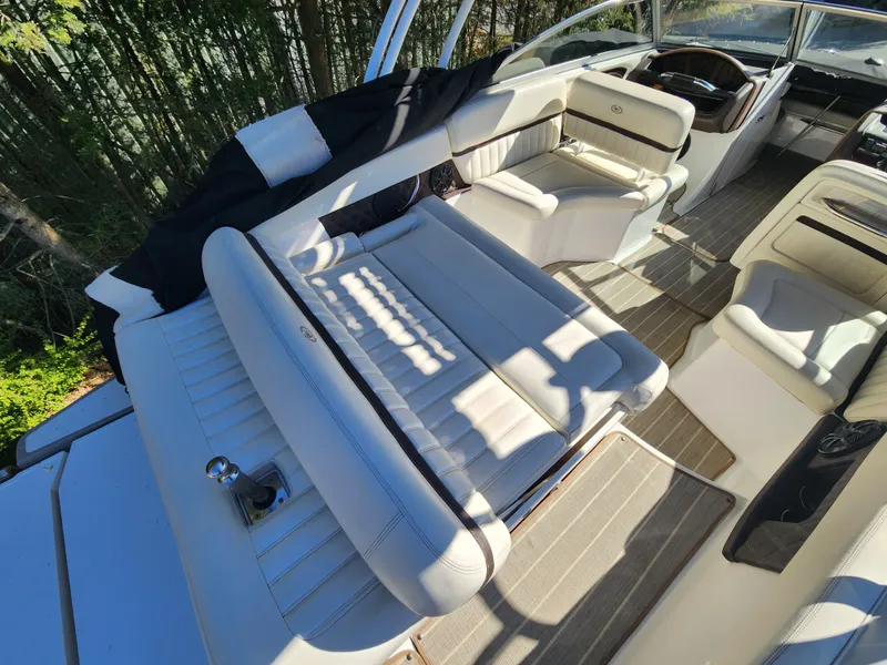 Slide: The Image of 2011 Cobalt A25 boat interior with white leather seating and wooden flooring. - 9