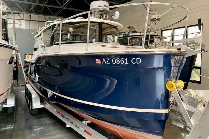 The Image of 2022 Ranger Tugs R-27 boat on trailer in indoor storage. - 1