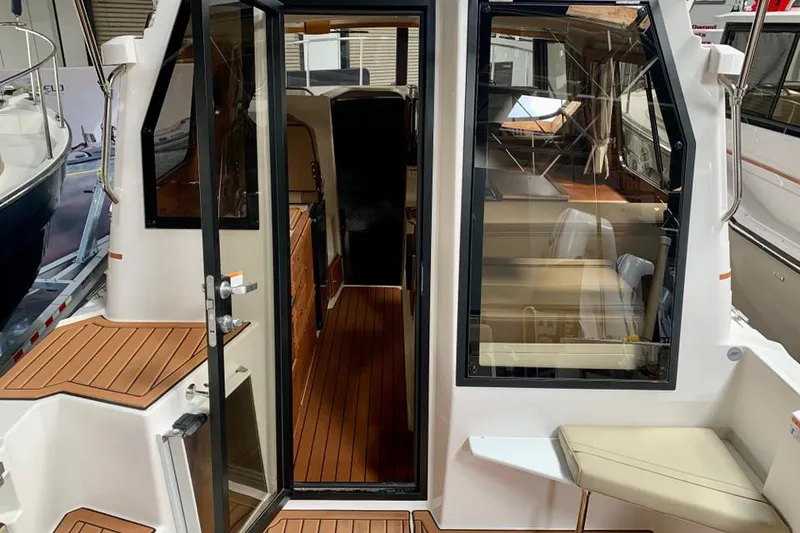 Slide: The Image of 2022 Ranger Tugs R-27 boat interior with teak flooring and seating area. - 4