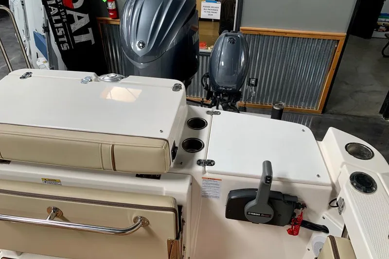 Slide: The Image of 2022 Ranger Tugs R-27 boat interior with outboard motor and seating area. - 5