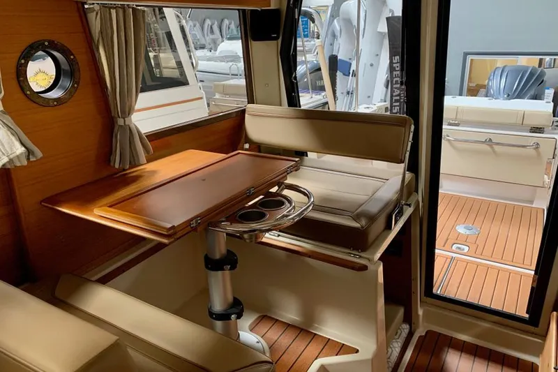 Slide: The Image of Interior of 2022 Ranger Tugs R-27 with wooden table and seating area. - 6