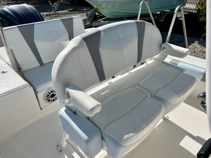 Slide: The Image of 2024 Robalo 246 Cayman boat seating area with white and gray upholstery. - 11