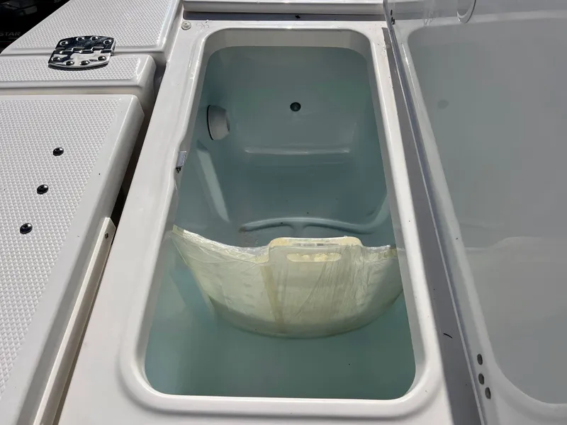 Slide: The Image of 2024 Robalo 246 Cayman livewell compartment with open lid. - 12