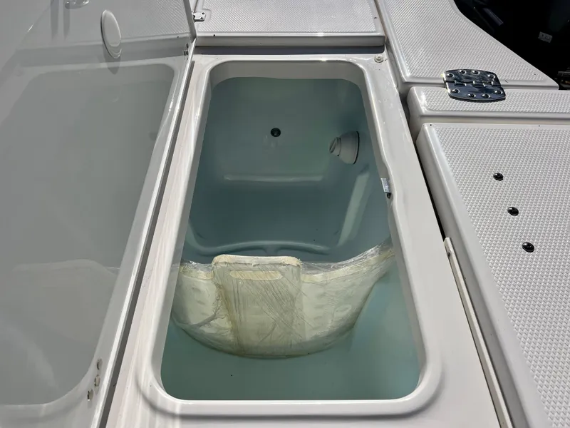 Slide: The Image of 2024 Robalo 246 Cayman livewell compartment with open lid. - 14