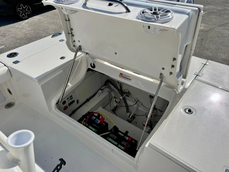 Slide: The Image of 2024 Robalo 246 Cayman boat battery compartment with open hatch and visible wiring. - 16