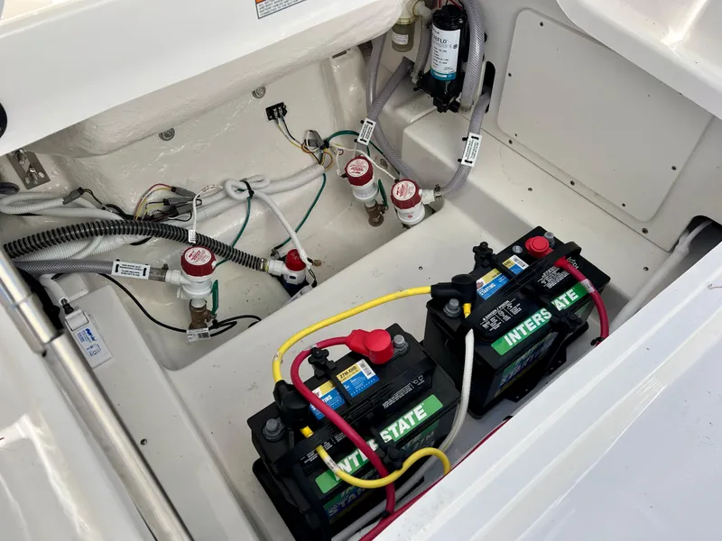 Slide: The Image of 2024 Robalo 246 Cayman boat battery compartment with Interstate batteries and wiring. - 18